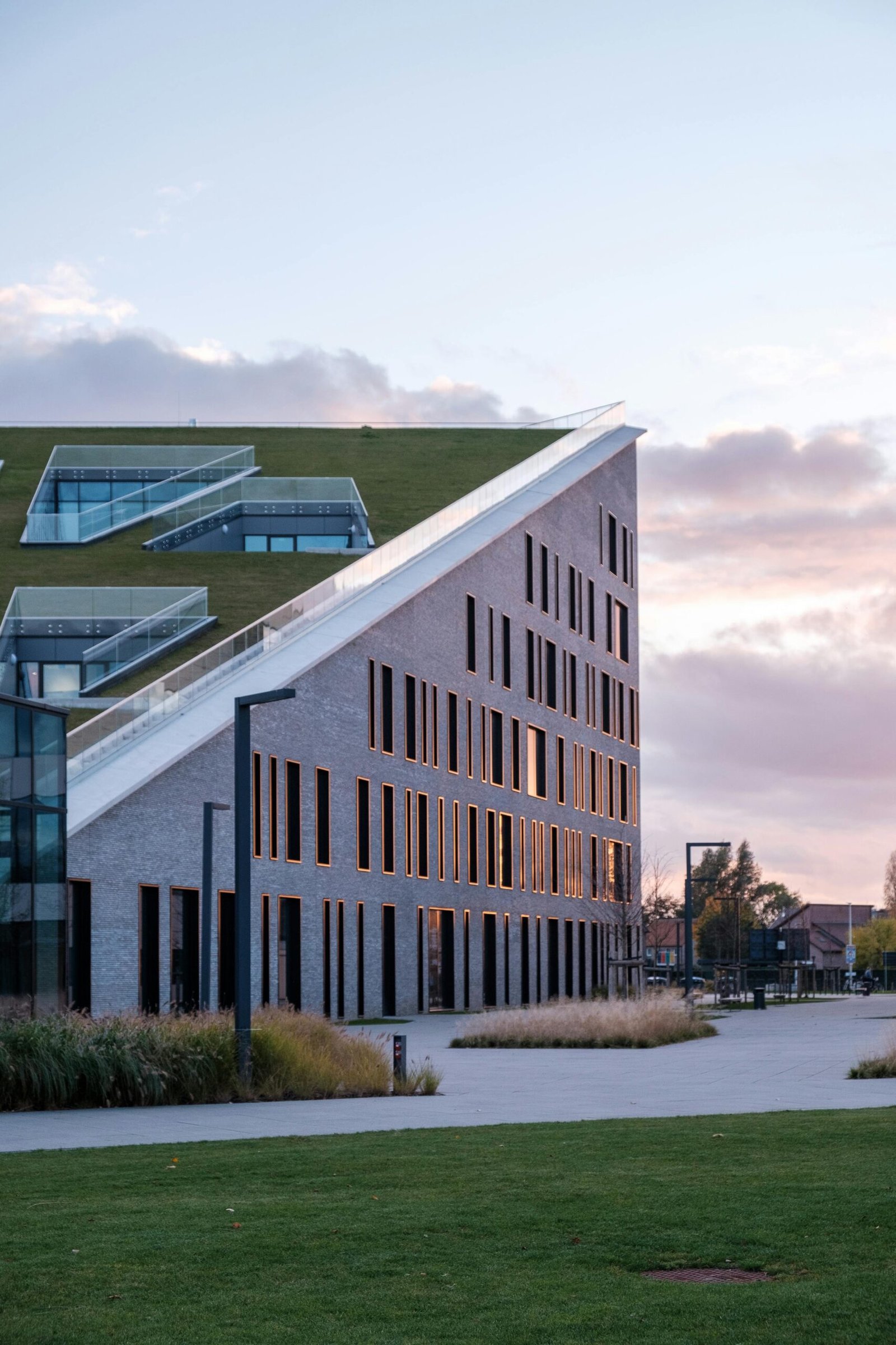 Elegant modern building with green roof at Corda Campus during dawn light in Hasselt.